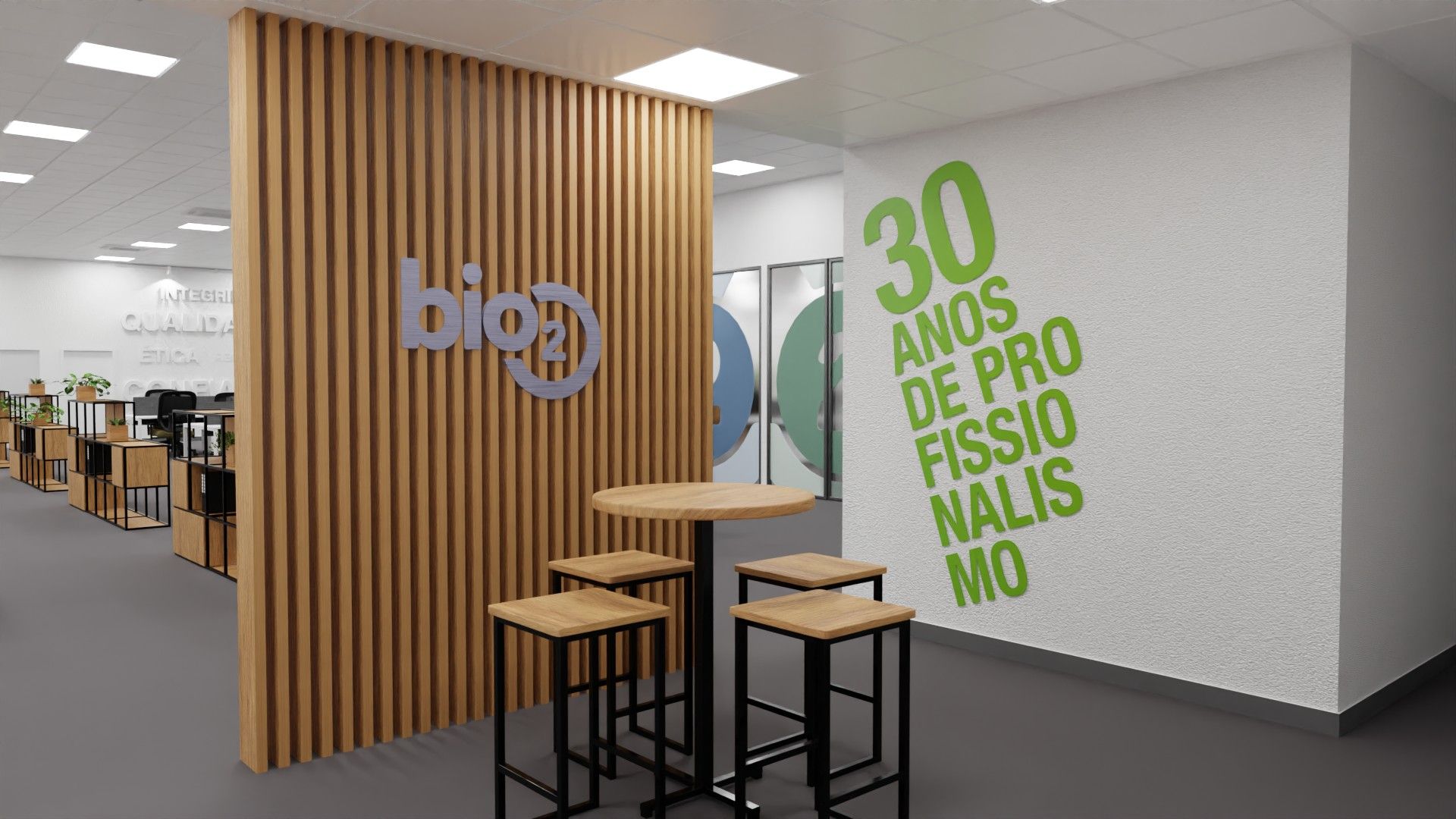 Zona de convívio, com painel de ripado de madeira e logótipo, mesa alta e a frase «30 anos de profissionalismo» na parede.