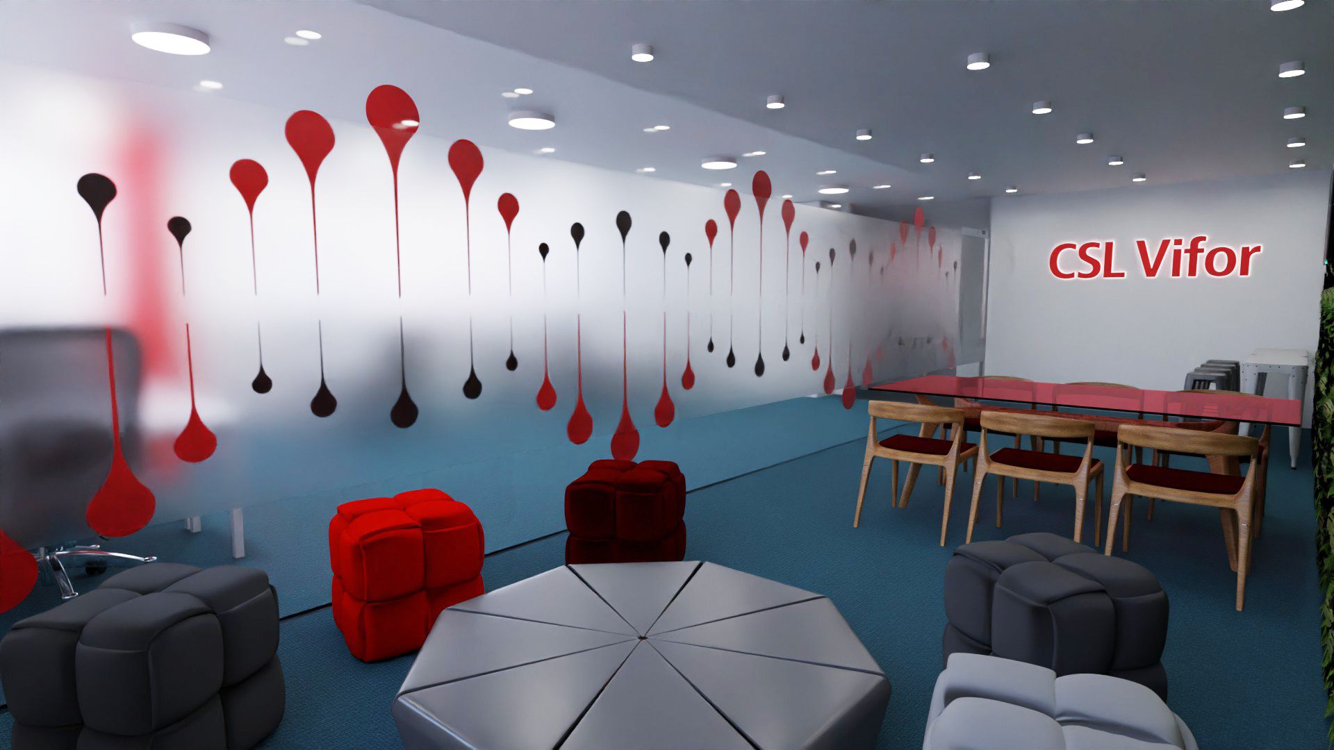 Sala de convívio da CSL Vifor, com parede de gotas vermelhas e pretas, pufes vermelhos e cinzentos, mesa central octogonal e o nome da marca na parede.