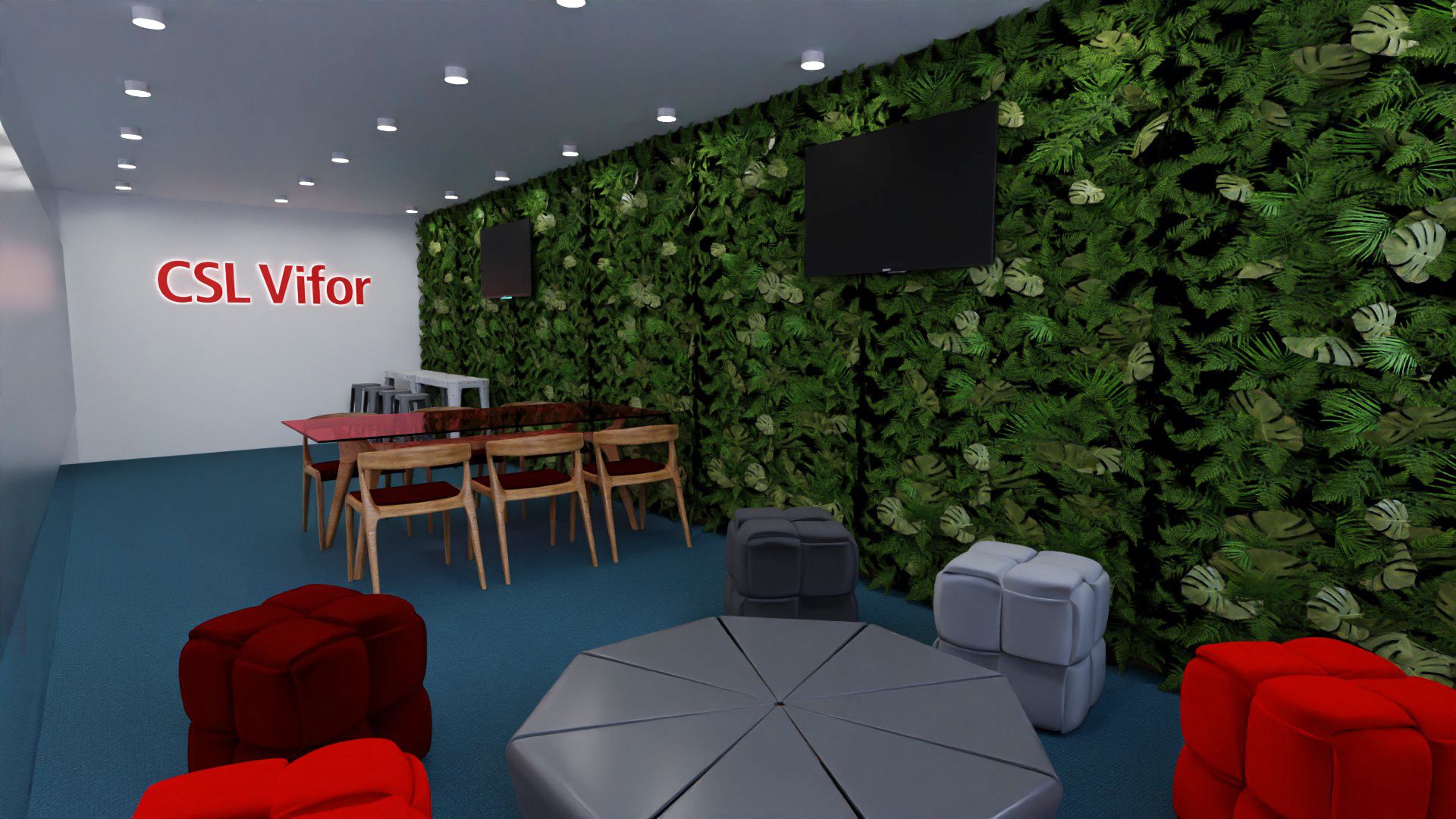 Sala de convívio com jardim vertical, televisões, mesa com cadeiras de madeira, pufes vermelhos e cinzentos, mesa central octogonal e o nome da marca na parede.